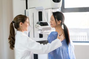 Female doctor adjusting patient's position to do a mammogram