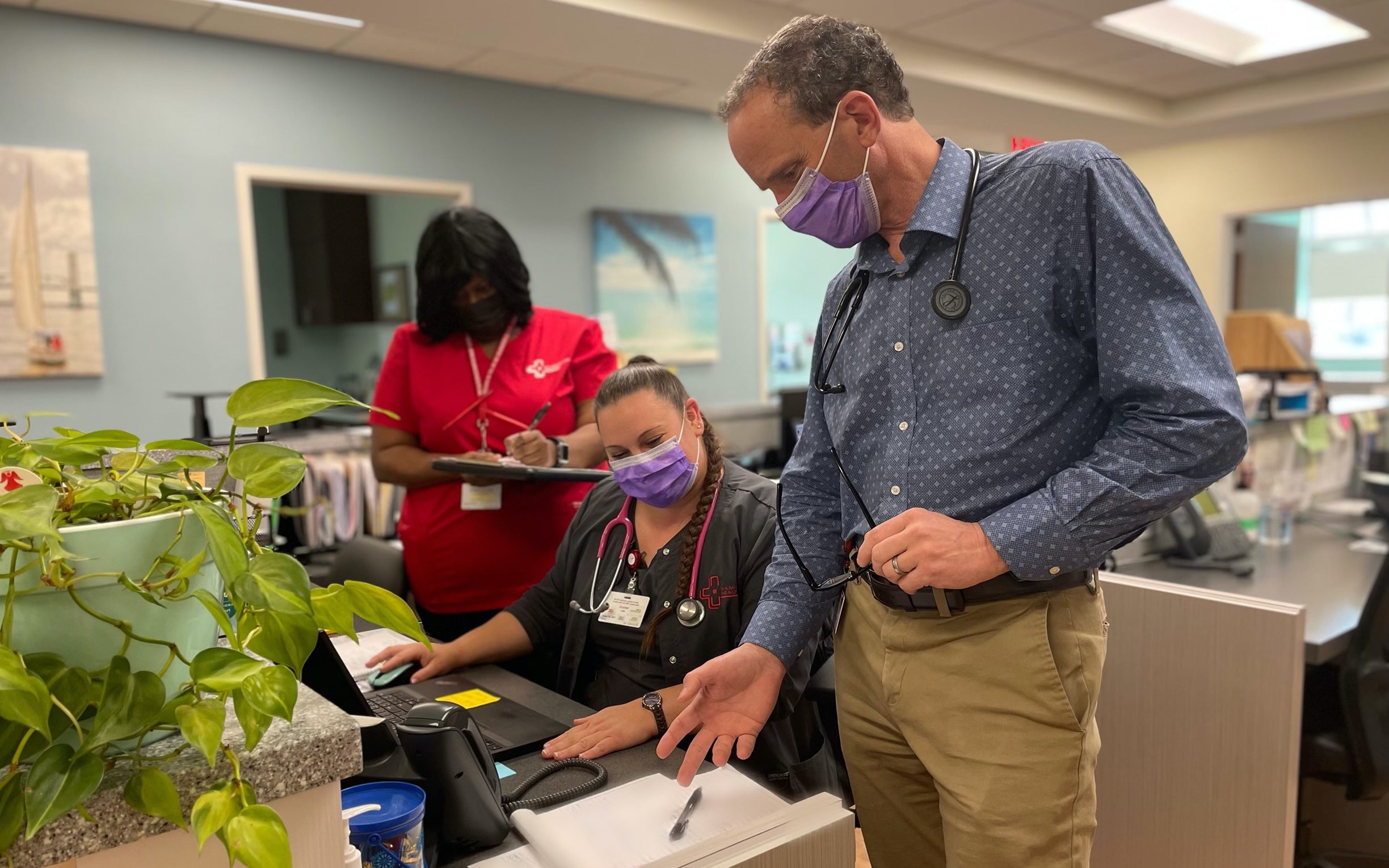 Medical Professionals conversing around a desk